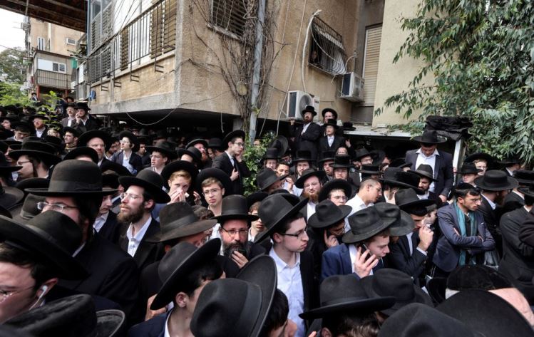 Ultra-Orthodox Jewish men gather for the funeral ceremony of prominent rabbi Chaim Kanievsky who died at 94, outside his home in Bnei Brak, near Tel Aviv, Israel March 20, 2022