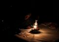 [File Image] A person works next to a paraffin lamp as Eskom implements regular power cuts across South Africa.