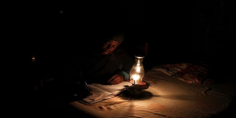 [File Image] A person works next to a paraffin lamp as Eskom implements regular power cuts across South Africa.