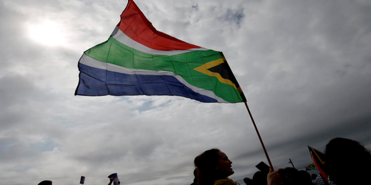 A person holds the South African flag