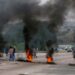 (FILE IMAGE) Supporters of former South African President Jacob Zuma block the freeway with burning tyres during a protest in Peacevale, South Africa, July 9, 2021.