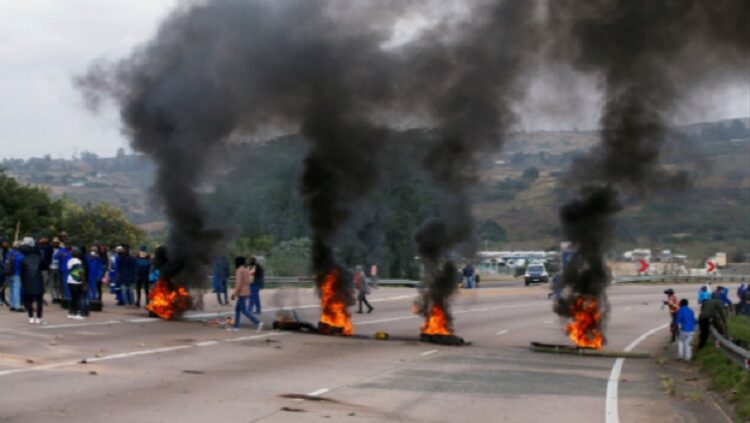Supporters of former South African President Jacob Zuma block the freeway with burning tyres during a protest in Peacevale, South Africa, July 9, 2021.