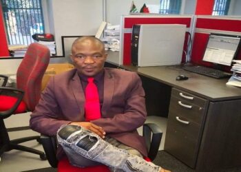 SABC News video journalist, Thabo Katsande, sitting by a desk