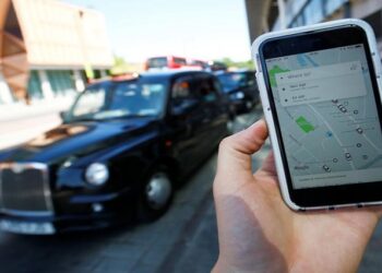 A photo illustration shows the Uber app on the mobile phone.