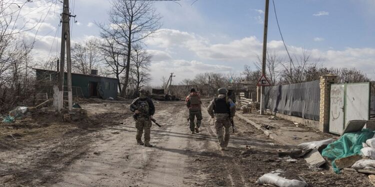 Ukranian servicemen walk through the village of Lukyanivka outside Kyiv, as Russia's invasion of Ukraine continues,  March 27, 2022.