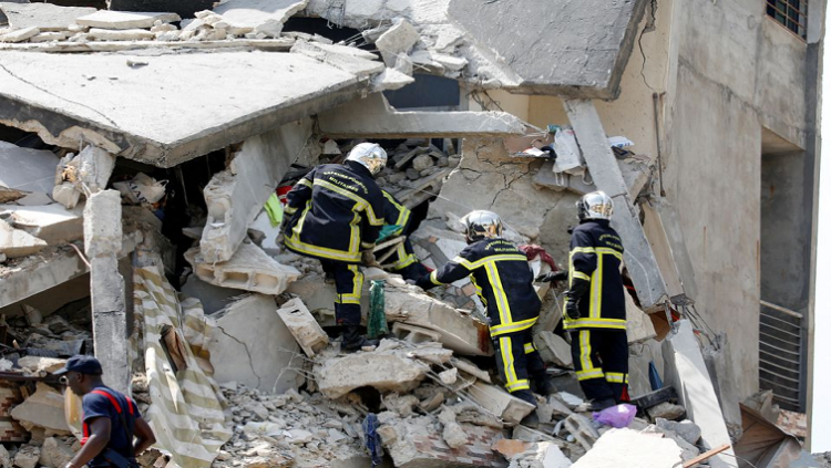 Firefighters search for survivors and bodies in the rubble of a collapsed apartment building in Abidjan, Ivory Coast March 7, 2022.