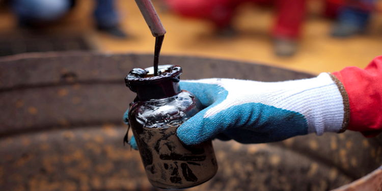 A worker collects a crude oil sample at an oil well operated by Venezuela's state oil company PDVSA in Morichal, Venezuela, July 28, 2011.