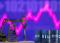 Models of oil barrels and a pump jack are displayed in front of a rising stock graph and "$100" in this illustration taken February 24, 2022.