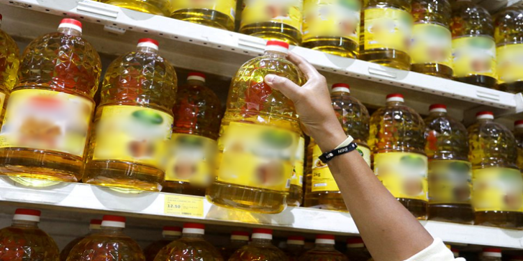 File image: A person holds bottles of cooking oil.