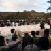 People stand in line to receive food donations, at the Tsehaye primary school, which was turned into a temporary shelter for people displaced by conflict, in the town of Shire, Tigray region, Ethiopia, 15 March 2021.