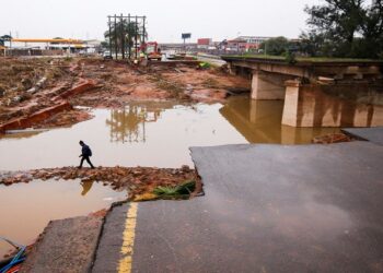 A person walks around a damaged bridge caused by flooding in Umlazi near Durban, South Africa, April 16, 2022.