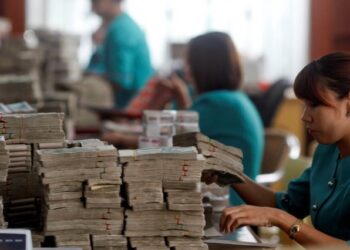 Workers count Myanmar's kyat banknotes at the office of a local bank in Yangon.