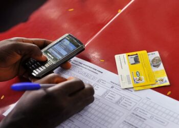 A man registers a SIM card as he attends to customers at a makeshift SIM card registration centre in Nigeria's capital Abuja August 3, 2010.
