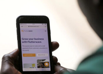 A man poses as he displays the Flutterwave homepage on a mobile phone screen in Abuja, Nigeria January 21, 2020.