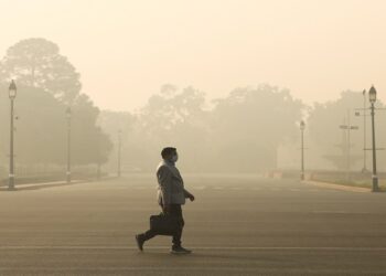 [File Image] A man walks along a road on a smoggy morning in New Delhi, India, December 23, 2020.