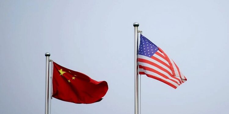 Chinese and U.S. flags flutter outside a company building in Shanghai, China April 14, 2021.