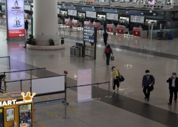 Travellers walk at a terminal hall of the Beijing Capital International Airport