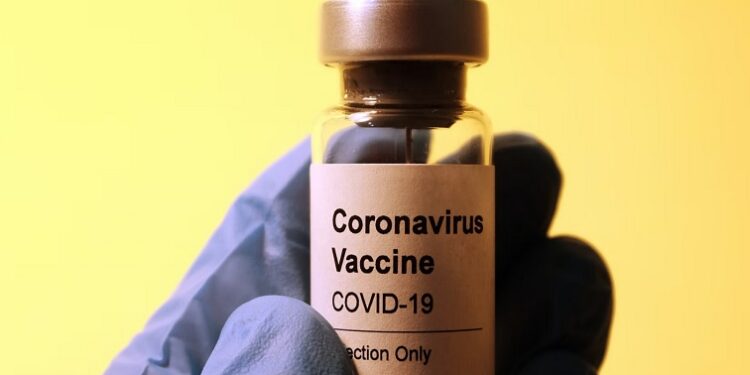 A health practitioner holding a coronavirus vaccine.