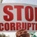 A person holds a stop corruption poster.