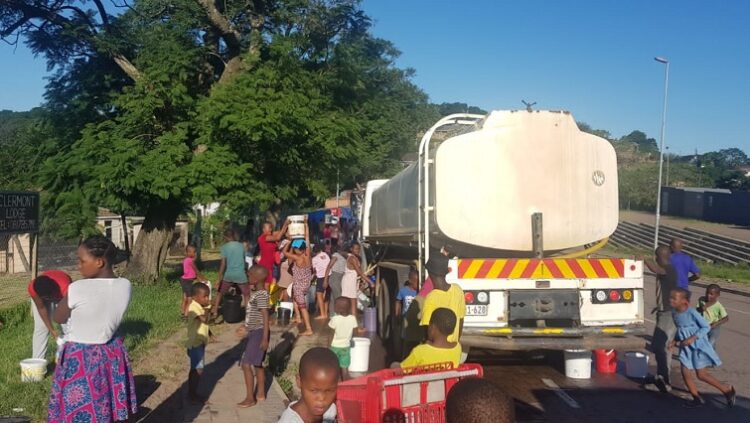Residents queue to get water.