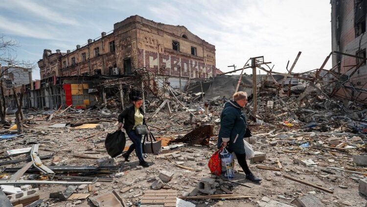 [File Image] Residents carry their belongings near buildings destroyed in the course of Ukraine-Russia conflict, in the southern port city of Mariupol, Ukraine April 10, 2022.