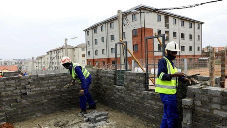 [File Image] Workers are seen building housing units at a construction site.