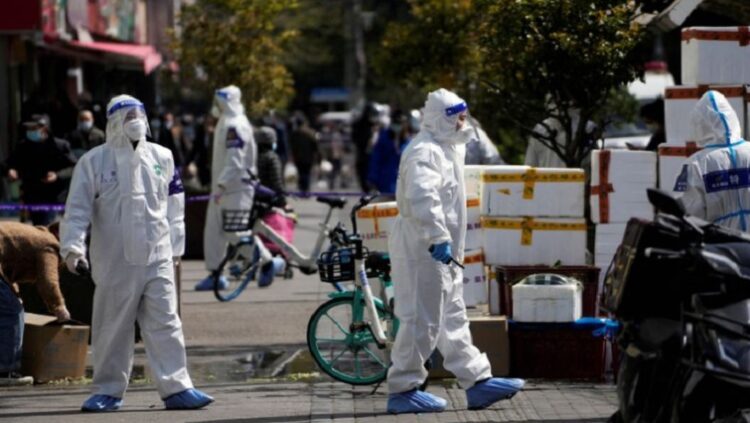 Police and security members in protective suits stand outside cordoned off food stores following the coronavirus disease (COVID-19) outbreak in Shanghai, China March 29, 2022.