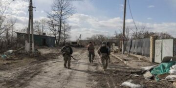 Ukranian servicemen walk through the village of Lukyanivka outside Kyiv, as Russia's invasion of Ukraine continues.
