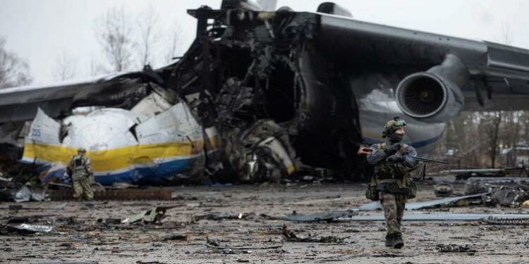 A Ukrainian service member walks in a front of an Antonov An-225 Mriya cargo plane, the world's biggest aircraft, destroyed by Russian troops amid Russia's attack on Ukraine continues, at an airfield in the settlement of Hostomel, in Kyiv region, Ukraine April 2, 2022.