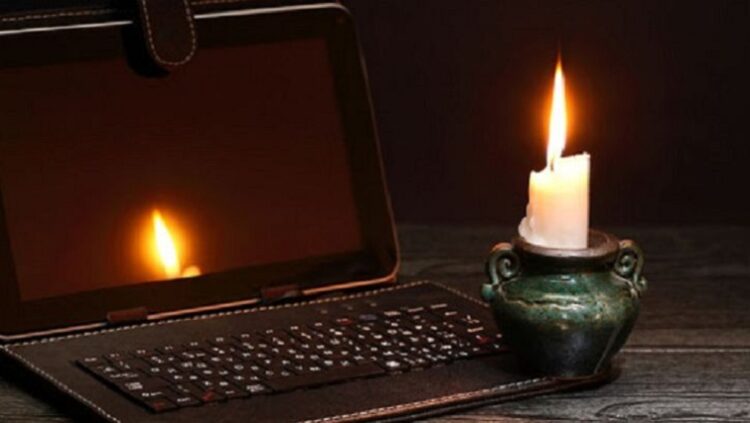 A laptop and candle during a blackout