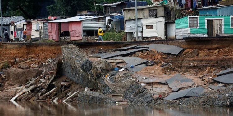 A man walks on a destroyed road after flooding in Umlazi near Durban, South Africa, April 16, 2022.