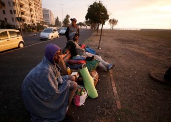 A group of homeless men take in the last of the days light before seeking a place to sleep on a deserted promenade during the 21-day nationwide lockdown aimed at limiting the spread of coronavirus disease (COVID-19) in Cape Town, South Africa, April 15, 2020.