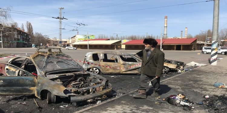 A man walks past burned cars at the site of a missile strike, at a rail station, amid Russia's invasion of Ukraine, in Kramatorsk, Ukraine April 8, 2022.