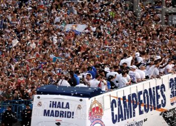 Real Madrid players celebrate winning LaLiga on top of the bus with fans at Cibeles fountain in Madrid.