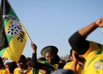 Supporters of the ANC hold the party's flags.