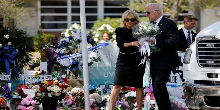 U.S. President Joe Biden and first lady Jill Biden hold a bouquet of 21 white flowers to be laid at the Robb Elementary School memorial, where a gunman killed 19 children and two teachers in the deadliest U.S. school shooting in nearly a decade, as they visit the school, in Uvalde, Texas, U.S. May 29, 2022.