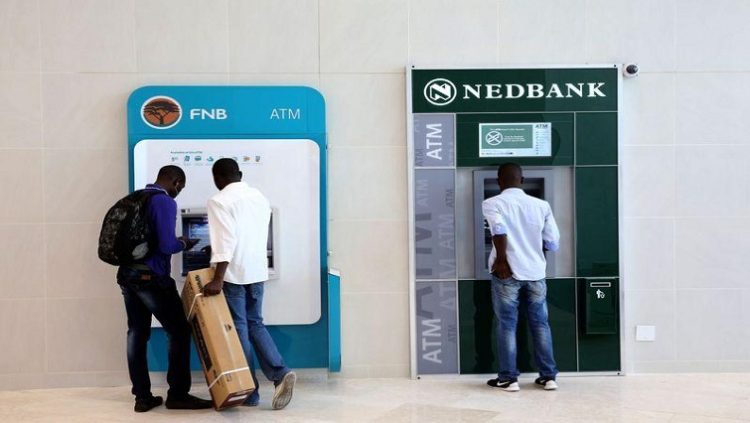 Customers are seen withdrawing money from FNB and Nedbank ATMs.  [File image]