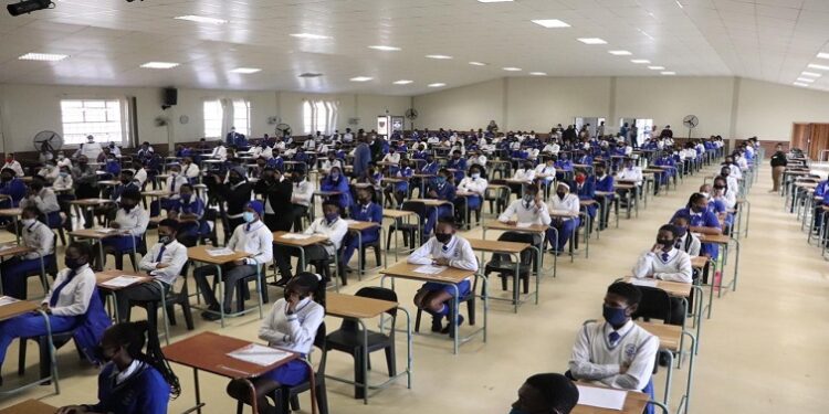 Pupils are seated in an exam room.