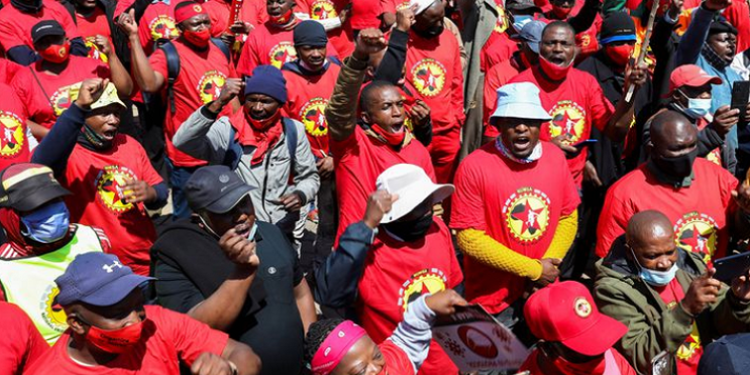 Members of the National Union of Metalworkers of South Africa (NUMSA) hold placards.