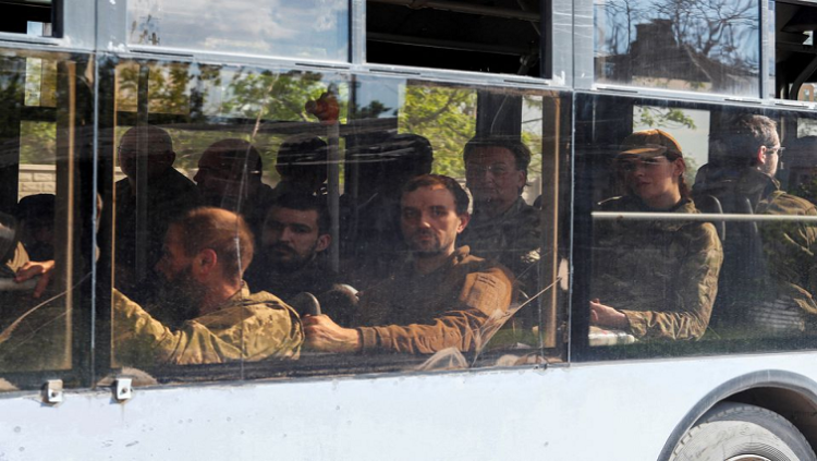 A bus carrying service members of the Ukrainian armed forces, who surrendered at the besieged Azovstal steel mill, drives away under escort of the pro-Russian military in the course of the Ukraine-Russia conflict, in Mariupol, Ukraine May 20, 2022. REUTERS/Alexander Ermochenko