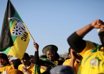 Supporters of the African National Congress hold the party flag during ANC campaign.