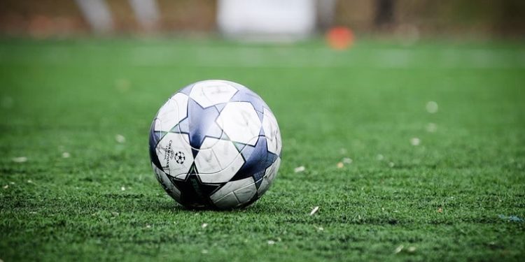 A soccer ball seen on a pitch.