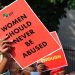 File image: A person holds an EFF branded poster written "Women should never be abused".