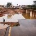 [File Image] A man walks around a damaged bridge caused by flooding in Umlazi near Durban.