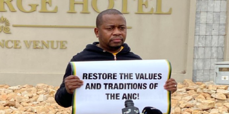 Mzwandile Masina holds a poster saying ANC integrity must be protected.
