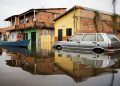 People in a canoe cross a car on a flooded street during floods caused by heavy rain in Maraba, Para state [File image]