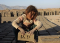 [FILE PHOTO] An Afghan girl works at a brick-making factory in Nangarhar province January 6, 2015. REUTERS