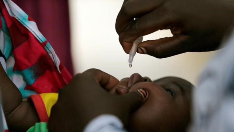 A child is given a dose of polio vaccine at an immunisation Health Centre in Nigeria.