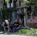 Local residents sit in a courtyard near a block of flats heavily damaged during the Ukraine-Russia conflict, in the southern port city of Mariupol, Ukraine May 20, 2022.