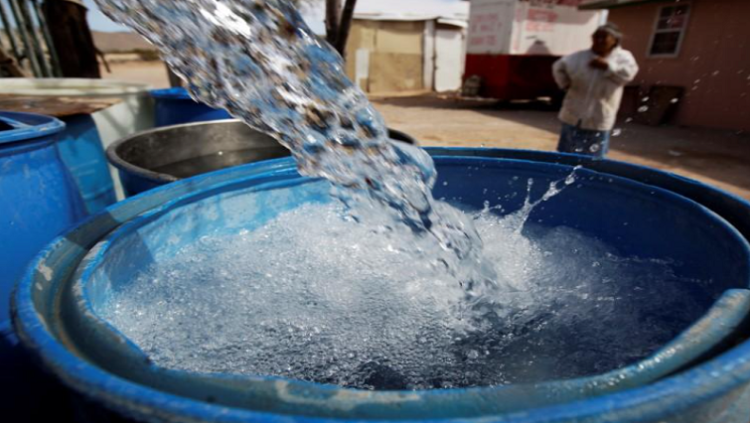 A bucket is seen being filled with water.